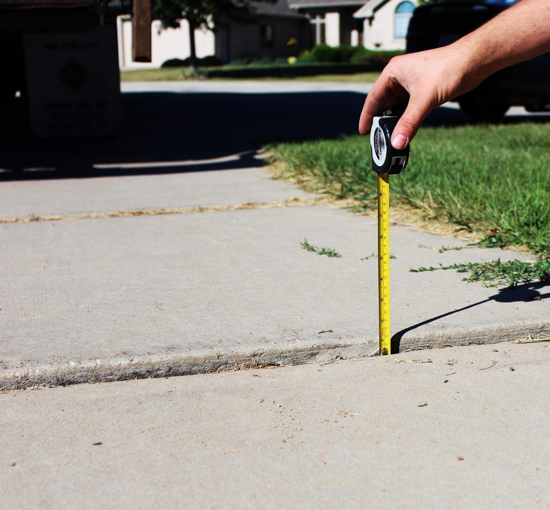 Sunken driveway apron with settled slab before polyurethane foam lifting